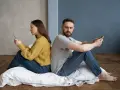 Para siedzi plecami do siebie, wpatrzona w telefony. Czy to przykład breadcrumbing co to znaczy?