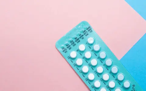 Opakowanie tabletek antykoncepcyjnych na różowym i niebieskim tle. Szukasz co zamiast tabletek antykoncepcyjnych?