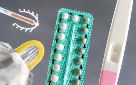 Różne rodzaje tabletek antykoncepcyjnych, wkładka domaciczna, prezerwatywa i test ciążowy.