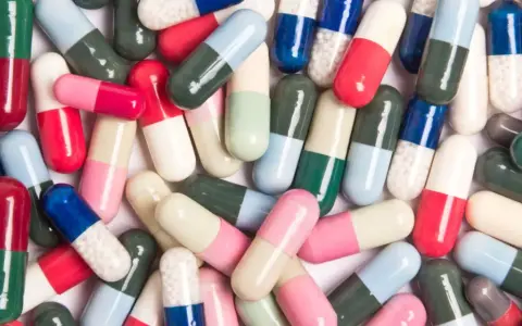 Kolorowe kapsułki leków, które mogą wywołać pieczenie pochwy po antybiotyku.