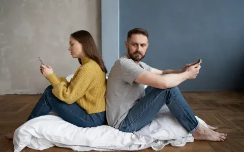 Para siedzi plecami do siebie, wpatrzona w telefony. Czy to przykład breadcrumbing co to znaczy?